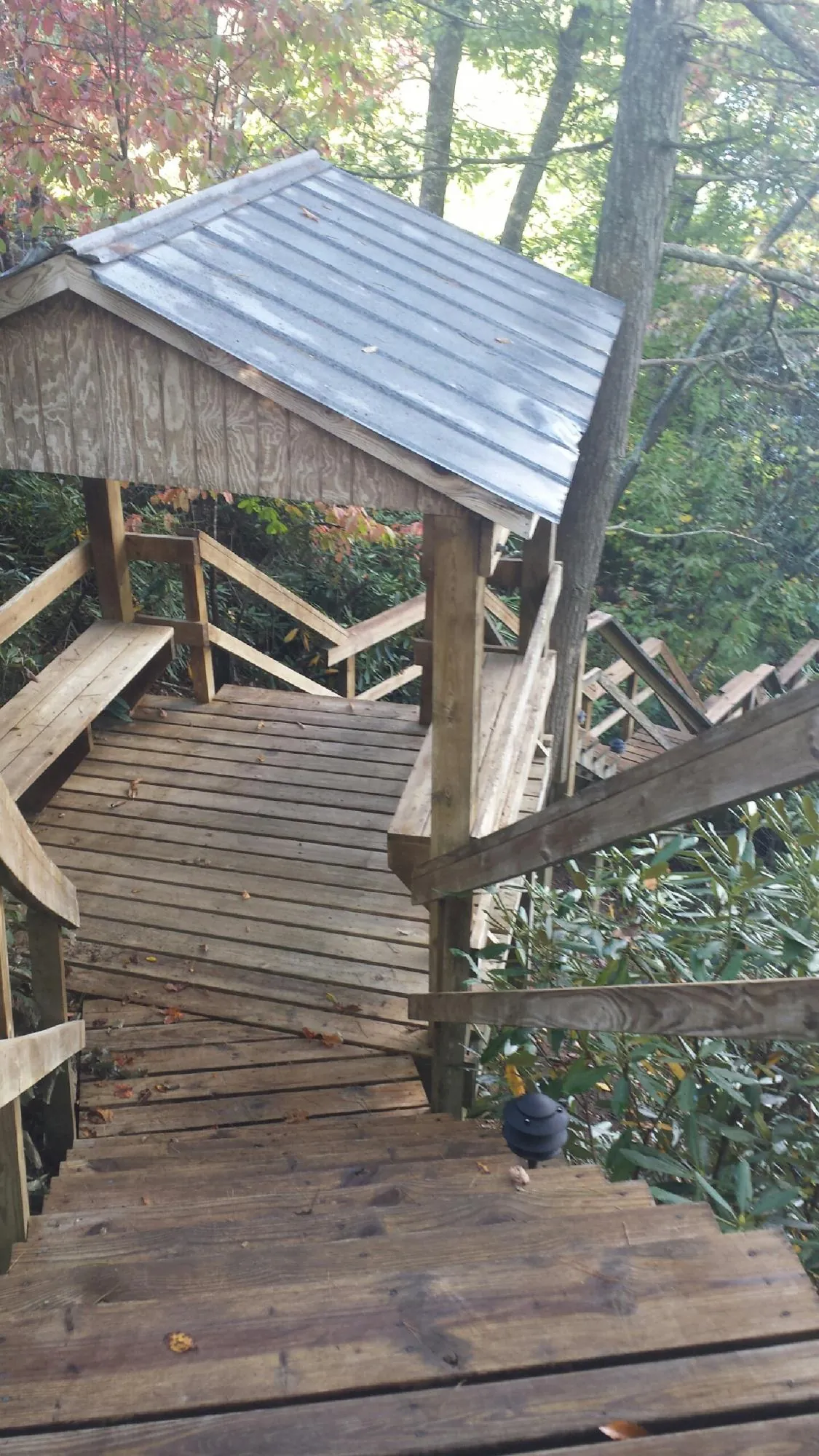 Metal roofed shelter over wooden steps on a wooded walkway — Skylight Repair & Installation work by our crew in Stockton